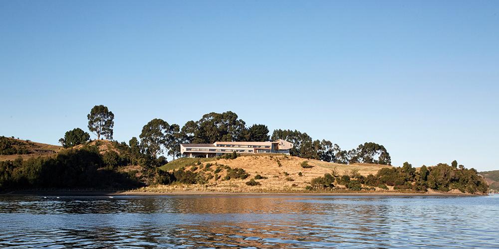 Cenários bucólicos são formados por florestas, praias e fiordes, que contrastam harmoniosamente com as tradicionais casas de madeira construídas sobre palafitas (Divulgação / Tierra Chiloé)