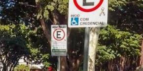 Placa de estacionamento com o símbolo do espectro autista em frente a uma escola de BH (Divulgação / PBH)