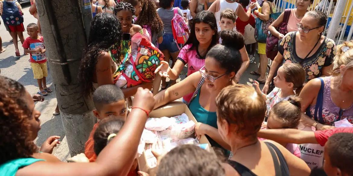 Fiéis distribuem doces em homenagem aos santos Cosme e Damião, no Andaraí, na zona norte da capital fluminense (TOMAZ SILVA/ AGÊNCIA BRASIL)