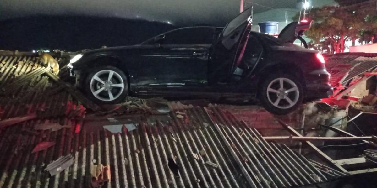 Carro ficou pendurado em cima de uma casa em Poços de Caldas (Divulgação/ CBMMG)