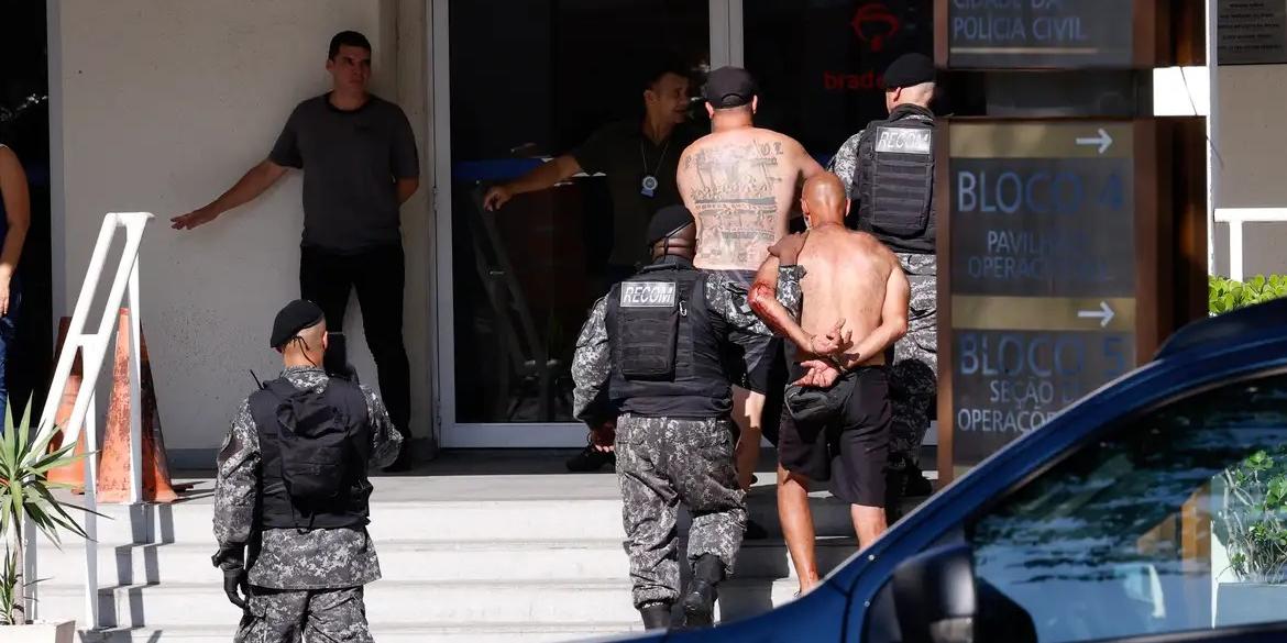 Torcedores do Peñarol presos na praia do Recreio, zona oeste do Rio de Janeiro (TÂNIA RÊGO/AGÊNCIA BRASIL)