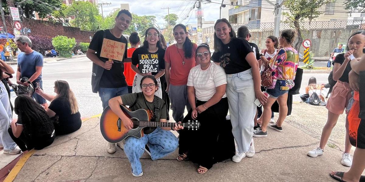 Com a ajuda de um violão, eles cantam e passam mensagens de incentivo aos alunos que vão chegando ao local (Fernando Michel)