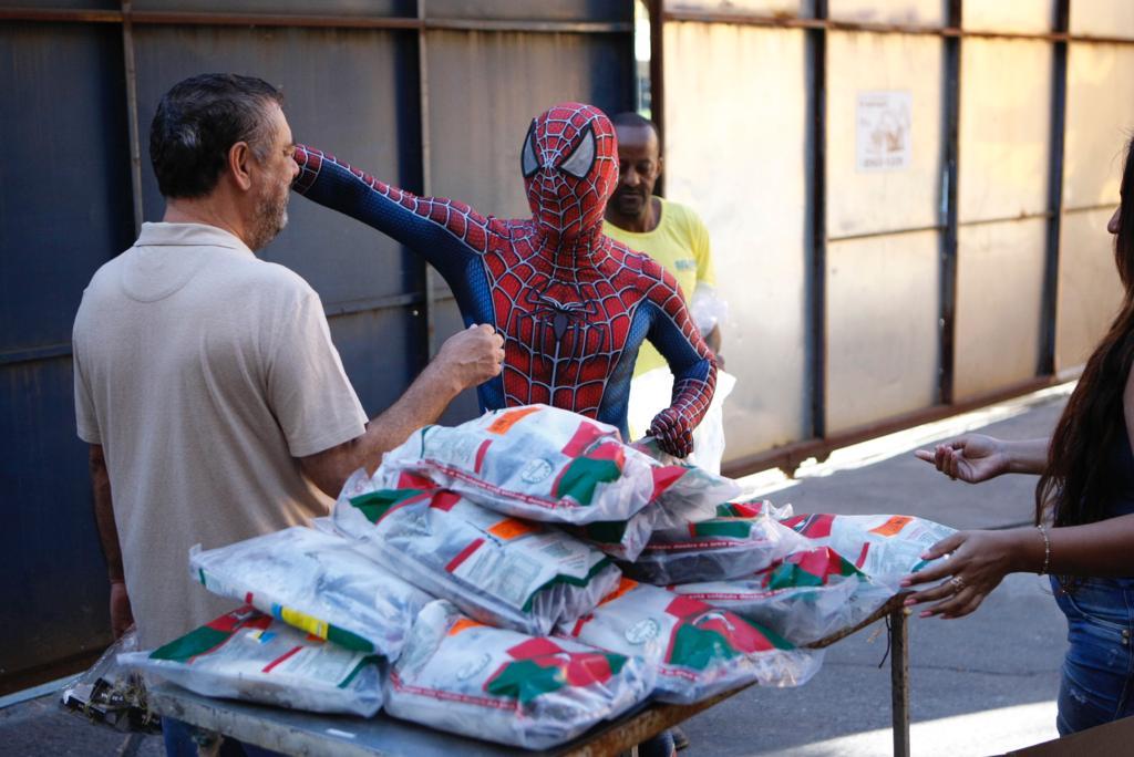 Homem-Aranha cumprimenta o idealizador da entrega de peixes, Alfonso Teixeira (Fernando Michel / Hoje em Dia)