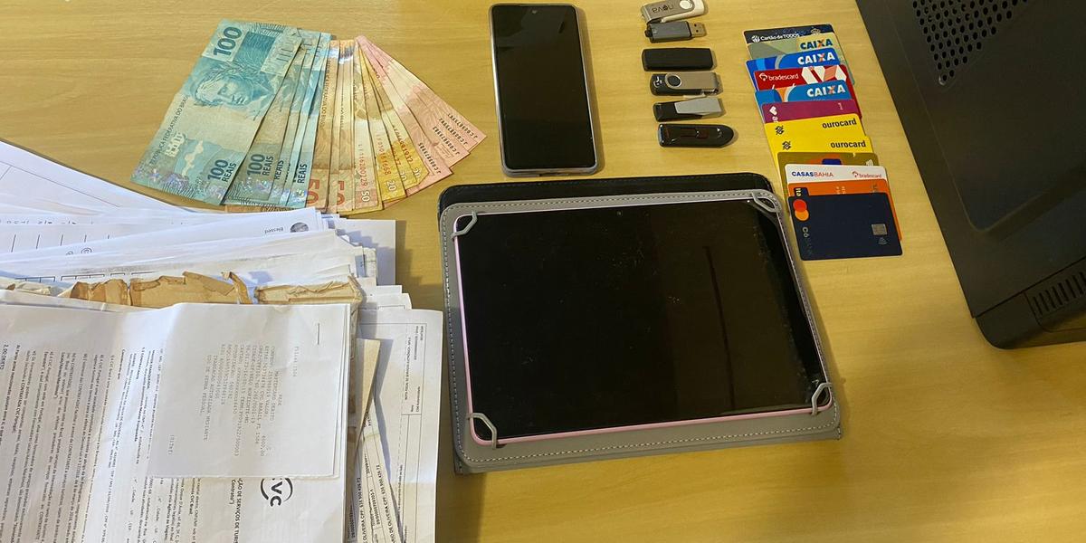 A Polícia Civil de Minas Gerais apreendeu celulares, pen drives, computadores, documentos, cartões bancários e mil reais (Divulgação / PCMG)