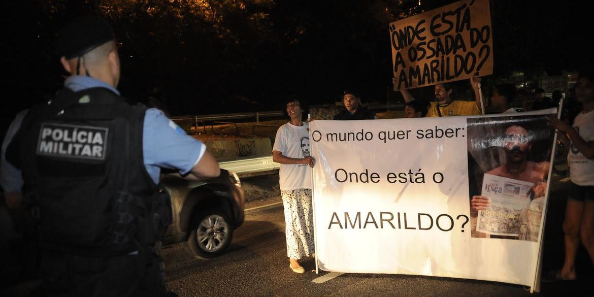 Policiais militares tentam conter manifestação, na Favela da Rocinha, para lembrar os dois anos de desaparecimento do ajudante de pedreiro Amarildo de Souza durante uma operação policial (Fernando Frazão / Agência Brasil)